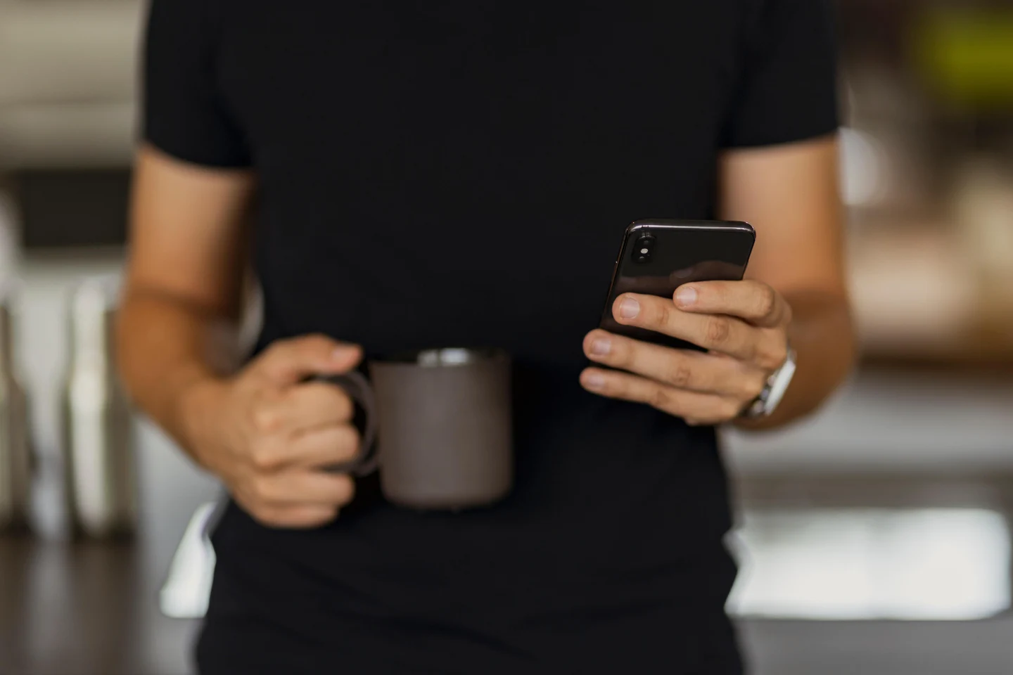 92a4b398-0f76-4f35-9387-c68690ee18bf-man-texting-his-phone-while-holding-black-coffee-cup-other-hand.jpg